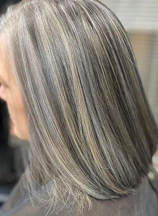 Shoulder-length silver-gray hair with blonde highlights, shown in profile indoors