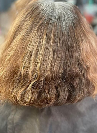 Back view of shoulder-length wavy light brown hair with blonde highlights