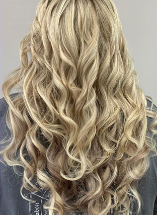 Long, wavy blonde hair with soft curls against a neutral background