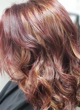 Side view of wavy auburn hair with pink and blonde highlights