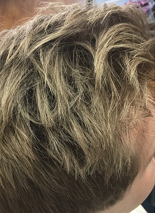 Close-up of short, tousled blonde hair with darker roots and highlights