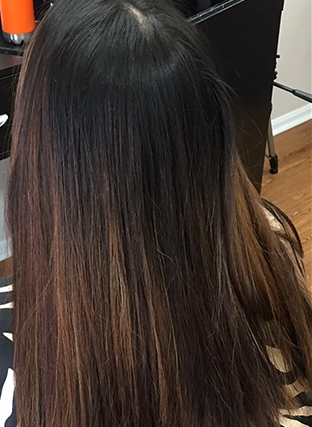 Long, straight dark brown hair with subtle lighter ends, viewed from behind indoors.