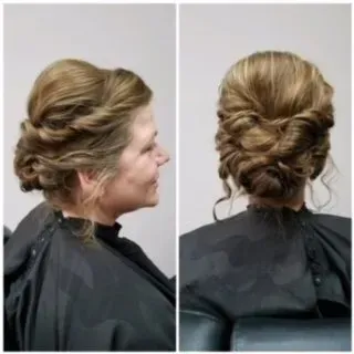 Bridal updo hairstyle shown from side and back on a woman wearing a black salon cape