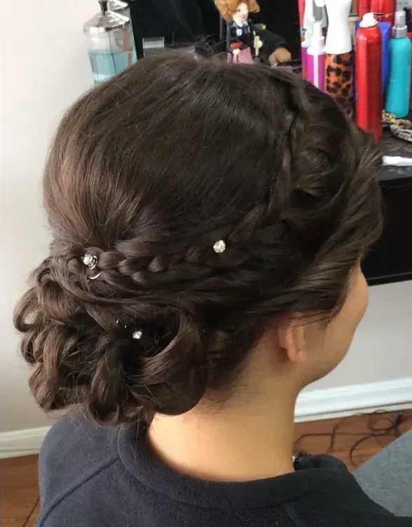 Braided updo with pearl accents at the back of the head in a salon setting