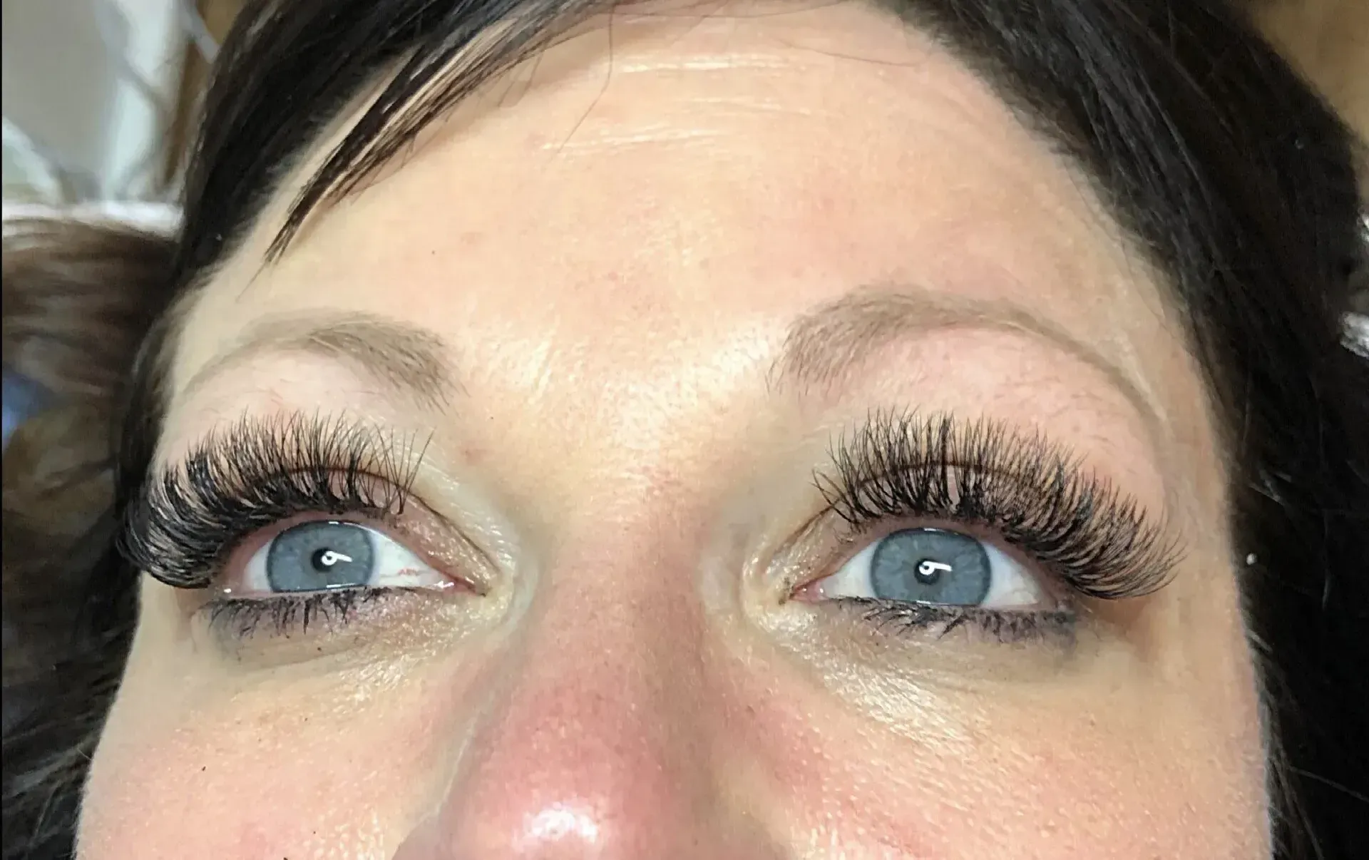Close-up of a person's eyes with blue irises and long eyelashes